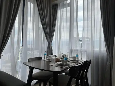 a table with chairs in front of a large window at Aurora Suites At Star Residences in Kuala Lumpur