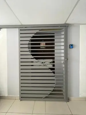 a metal garage door with a sign on it at Nour Homestay KLCC View - COMFORT in Kuala Lumpur