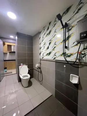 a bathroom with a toilet and a painting on the wall at Nour Homestay KLCC View - COMFORT in Kuala Lumpur