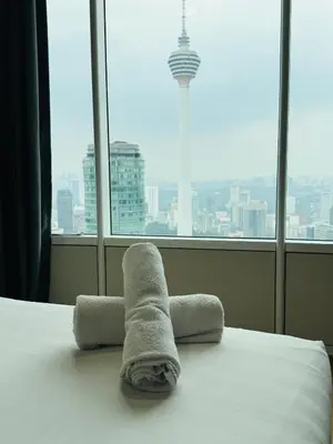 a hotel room with a bed with a towel on it at Sky Suites KLCC Luxury Cozy Suites in Kuala Lumpur