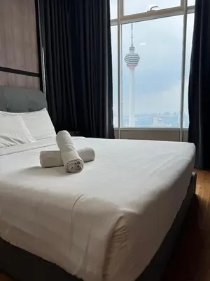 a bed with towels on it in a room with a window at Sky Suites KLCC Luxury Cozy Suites in Kuala Lumpur