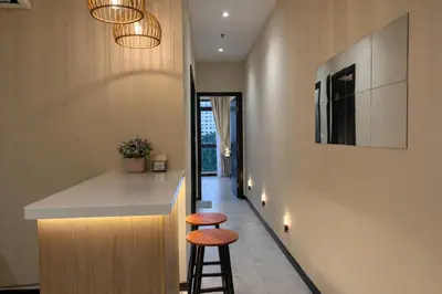 a kitchen with a counter and two stools at Neu Suites Kuala Lumpur By Vglory Home in Kuala Lumpur