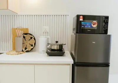 a kitchen with a microwave on top of a refrigerator at Cozy Cityscape Homestay in KL City Center 1-5pax in Kuala Lumpur