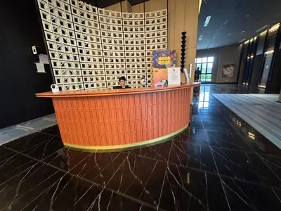 an empty lobby with an orange counter in a building at Majestic Suites Klcc BY Mimi in Kuala Lumpur