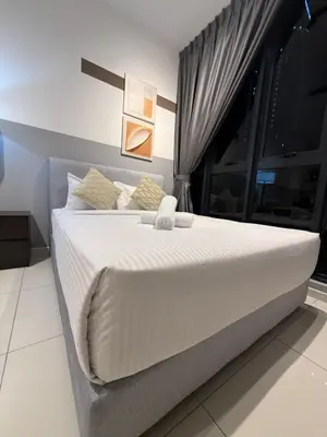 a large white bed in a room with a window at Majestic Suites Klcc BY Mimi in Kuala Lumpur