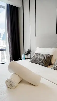 a white bed with a towel on it in a bedroom at Axon in Kuala Lumpur