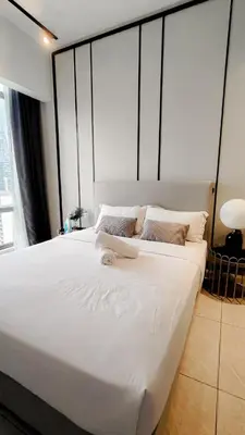 a large white bed with a laptop on top of it at Axon in Kuala Lumpur