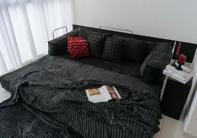 a bed with a blanket and a book on it at Cool Cityscape Homestay in KL City Center 1-5pax in Kuala Lumpur