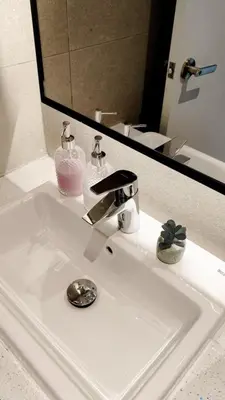 a bathroom sink with a faucet and a mirror at Axon premier suites, Pavilion Bukit bingtang, KL Tower in Kuala Lumpur