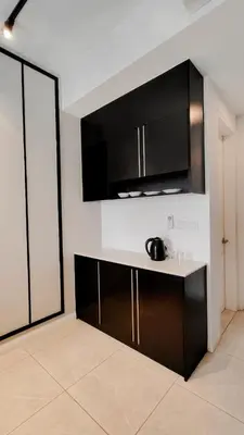 a kitchen with black cabinets and a counter top at Axon premier suites, Pavilion Bukit bingtang, KL Tower in Kuala Lumpur