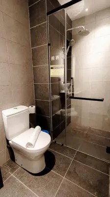 a bathroom with a toilet and a glass shower at Axon premier suites, Pavilion Bukit bingtang, KL Tower in Kuala Lumpur
