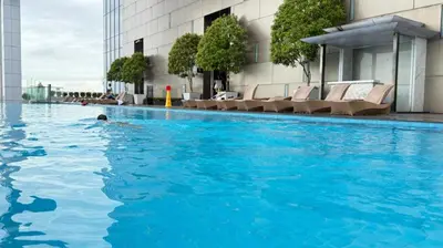 a person swimming in a pool in a building at The Platinum KLCC By Pool Point in Kuala Lumpur