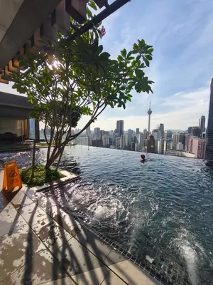 a swimming pool on the roof of a building with a city skyline at AXON RESIDENCE by DREAM HOME in Gua Sai