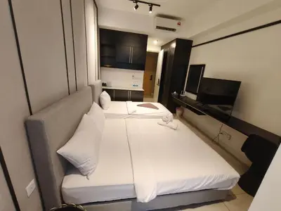 a bedroom with a large white bed and a television at AXON RESIDENCE by DREAM HOME in Gua Sai