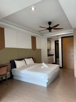 a bedroom with a white bed with a ceiling fan at Casa Bukit Bintang By Eryan Guest House in Kuala Lumpur
