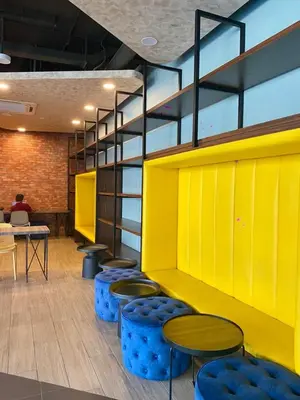a room with blue stools and a yellow wall at Neu Suites KLCC by HMM Home in Kuala Lumpur