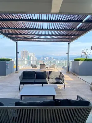 a patio with couches and tables on a roof at Neu Suites KLCC by HMM Home in Kuala Lumpur