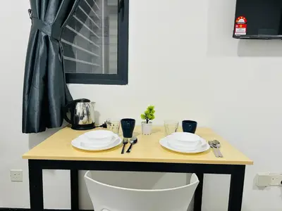 a table with plates and utensils on it at Neu Suites Apartment - Cozy Modern Stay near KLCC in Kuala Lumpur