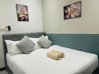 a white bed with a towel on top of it at Neu Suites Apartment - Cozy Modern Stay near KLCC in Kuala Lumpur