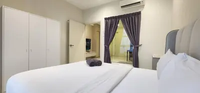 a white bed with a hat sitting on top of it at Arte Mont Kiara By Whitedoorz in Kuala Lumpur