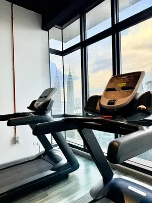 a gym with a treadmill and a large window at The Manor Kuala Lampur in Kuala Lumpur