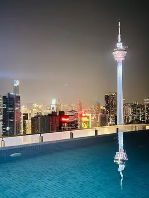 a rooftop pool with a view of a city at night at LUXE KLCC SKY LiNE in Kuala Lumpur