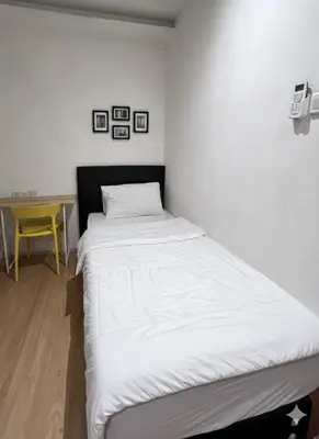 a white bed in a room with a yellow table at Ocean 77 by Pillow Plus Petaling Street KL in Kuala Lumpur