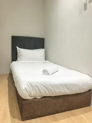 a large bed with white sheets and a black headboard at Ocean 77 by Pillow Plus Petaling Street KL in Kuala Lumpur