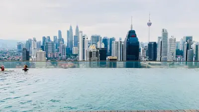 a infinity pool with a view of the singapore city at RegaliaA Residences in Kuala Lumpur