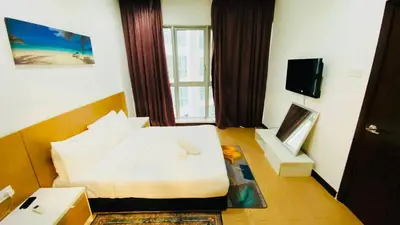 a hotel room with a bed and a television at RegaliaA Residences in Kuala Lumpur
