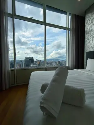 a hotel room with a bed and a large window at Sky Suites KLCC by Tareen Haven suites in Kuala Lumpur