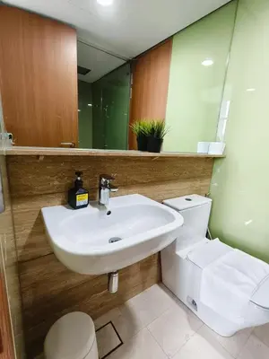 a bathroom with a sink and a toilet and a mirror at Sky Suites KLCC by Tareen Haven suites in Kuala Lumpur