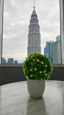 a plant sitting on a table in front of a building at Sky Suites KLCC by Tareen Haven suites in Kuala Lumpur