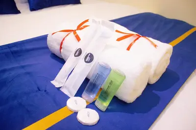 a bed with a pillow and some items on it at Astarr Hotel KL in Kuala Lumpur