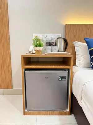 a tv with a table on top of it next to a bed at Astarr Hotel KL in Kuala Lumpur