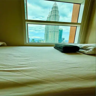 a bed in a room with a view of a city at KLCC Sky suites apartment bukit bintang in Kuala Lumpur