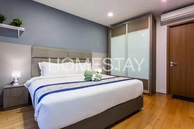 a bedroom with a large bed with a teddy bear on it at VORTEX SUITES KLCC By HOMESTAY in Kuala Lumpur