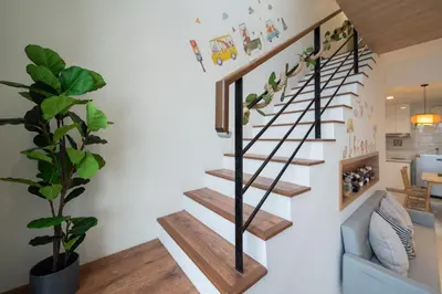 a staircase in a living room with a plant at 9pax, Slide, RockClimbing, Arcade, near City & MITEC in Kuala Lumpur