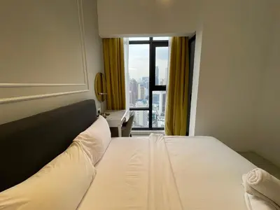 a bed in a hotel room with a window at IKON SUITE's A X O N BUKIT BINTANG in Kuala Lumpur