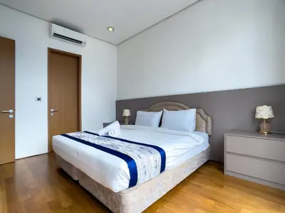 a bedroom with a large bed with white sheets at SOHO SUITES KLCC BY Homestay in Kuala Lumpur