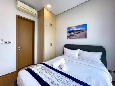 a bedroom with a large bed with white sheets at SOHO SUITES KLCC BY Homestay in Kuala Lumpur