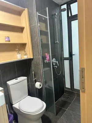 a bathroom with a toilet and a glass shower at The Colony Infinitum KLCC Suits By Saidul in Kuala Lumpur