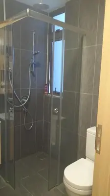 a bathroom with a toilet and a glass shower at The Colony Infinitum KLCC Suits By Saidul in Kuala Lumpur