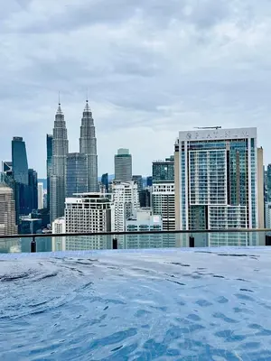 a view of a city skyline from a rooftop swimming pool at The Luxe Colony KLCC By KUALA LUMPUR in Kuala Lumpur