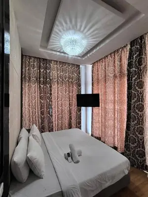 a bedroom with a white bed and a chandelier at The Dorsett Bukit Bintang KL in Kuala Lumpur