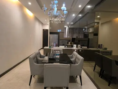 a dining room with a chandelier and a table and chairs at The Dorsett Bukit Bintang KL in Kuala Lumpur