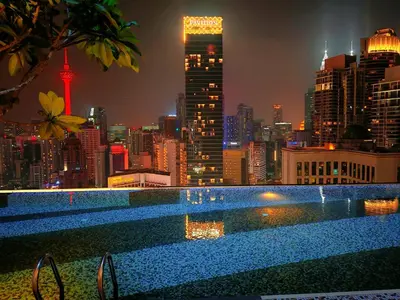 a swimming pool with a city skyline at night at Kuala Lumpur Services Apartments In A X O N Residence in Kuala Lumpur
