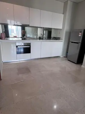 an empty kitchen with white cabinets and a refrigerator at Sky suites klcc Family suites home in Kuala Lumpur