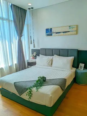 a bedroom with a large bed with a plant on it at Sky suites klcc Family suites home in Kuala Lumpur
