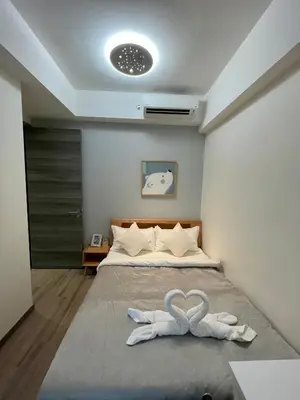 a bedroom with a bed with two white towels at Bukit Bintang Service Apartment in Kuala Lumpur